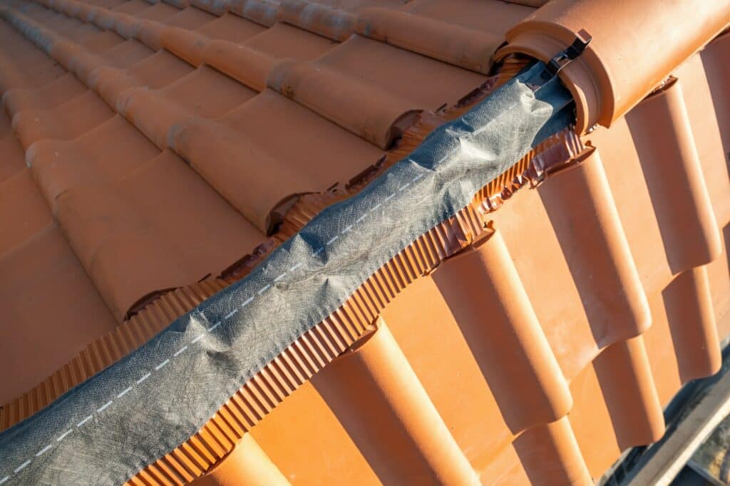 Closeup of yellow ceramic roofing ridge tiles on top